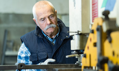 Worker using manufacturing equipment
